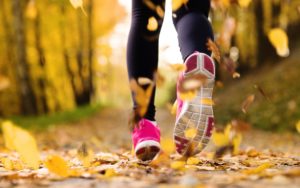 feet in running shoes on leafy trail